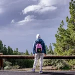 Solo traveler with backpack waiting at airport departure gate, ready for first solo adventure