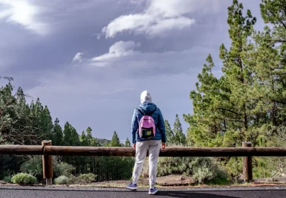 Solo traveler with backpack waiting at airport departure gate, ready for first solo adventure